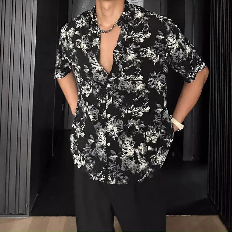 Man wearing a loose black floral print short sleeve casual shirt with a cardigan style open front.