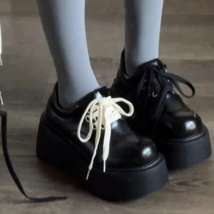 Matte black women's high-heel shoes with a thick rubber sole and lace-up buckle.