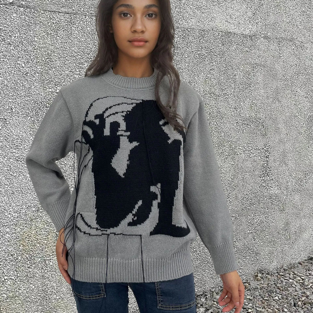 Grey women's alpaca wool pullover sweater with abstract pattern and tassel detailing on a hanger.