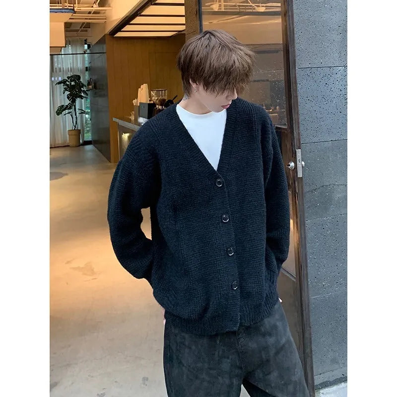 Men's loose fit V-neck knitted cardigan sweater in a solid colour on a hanger.