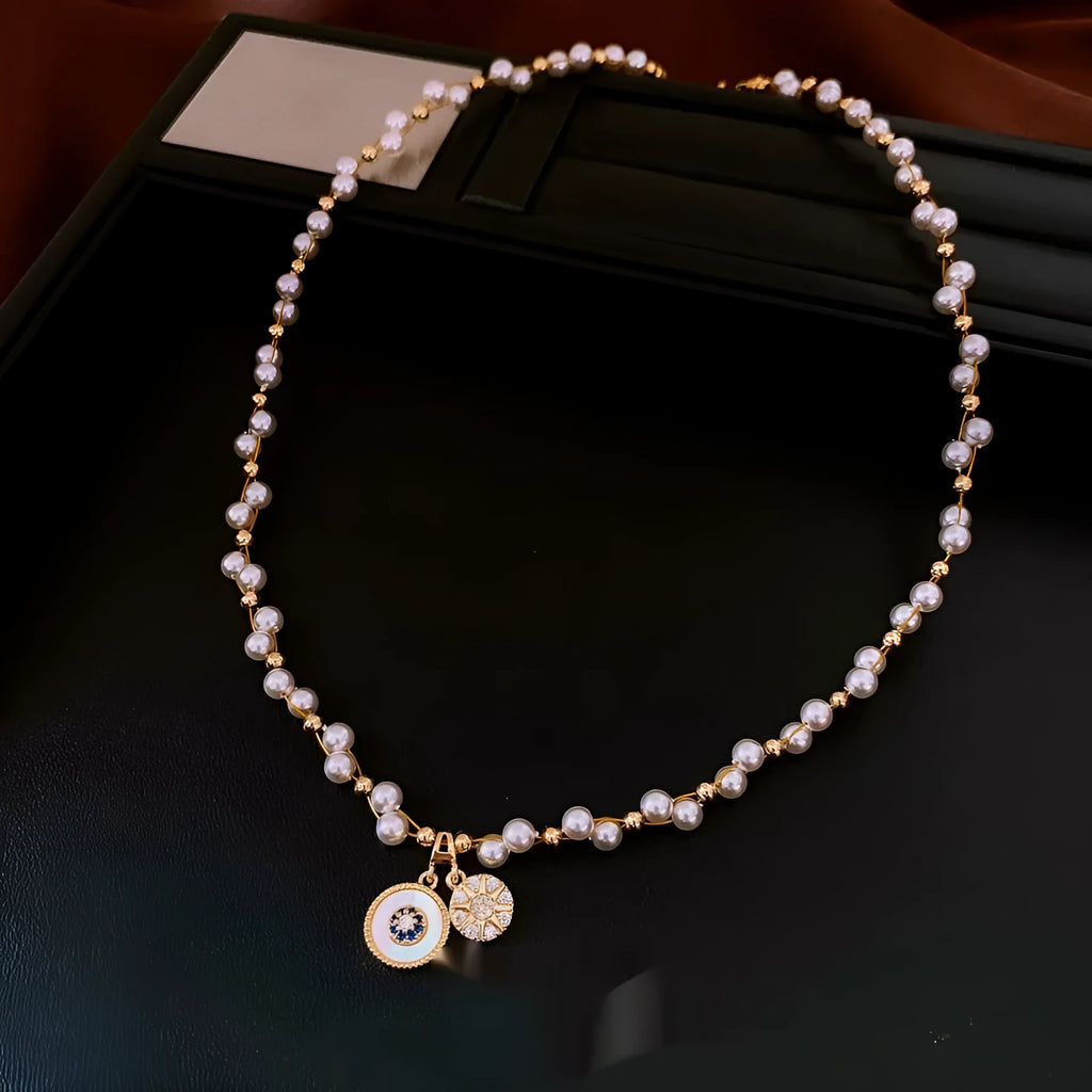 Gold electroplated clavicle necklace with round geometric pendant containing zircon inlay and imitation pearl centrepiece