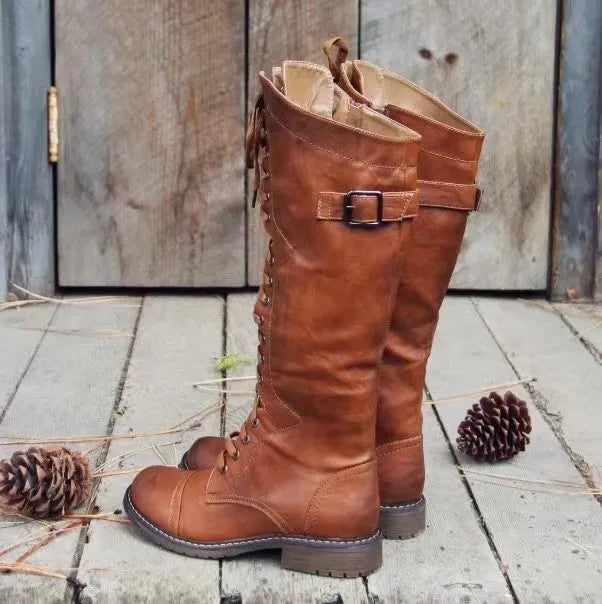 Women's black chunky heel high-leg boots with a round toe and low block heel on a plain background.