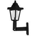 Black hexagonal solar wall lamp with light sensor mounted on an outdoor wall