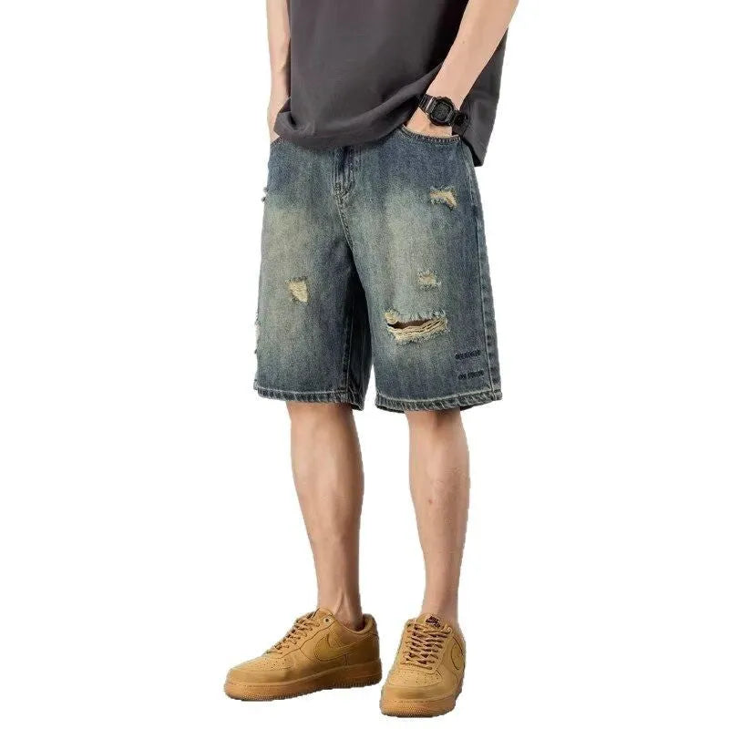 Man wearing blue retro distressed denim shorts with a straight leg cut.