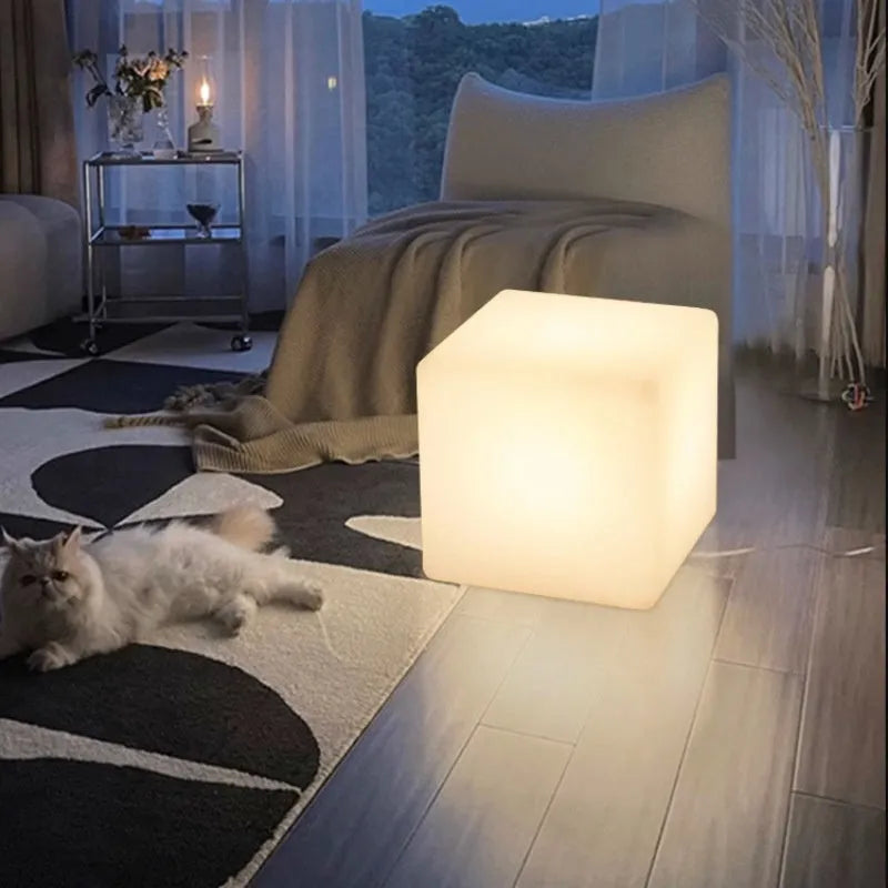 White square LED cube stool light for outdoor use, showing modern design with solar panel or charging port.