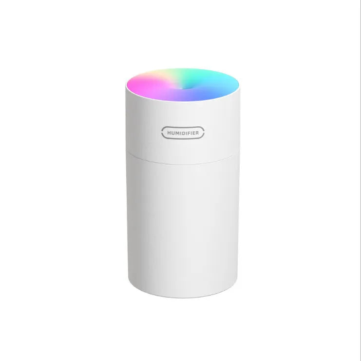 Pink USB mini humidifier with LED lights and water tank on desk