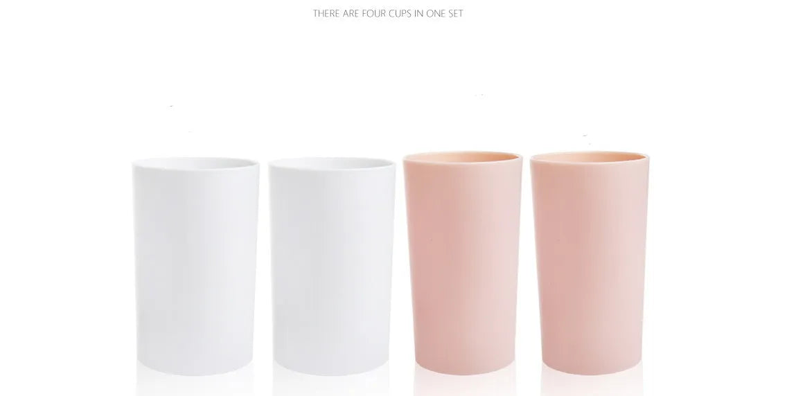 Plastic wall-mounted toothbrush holder with four magnetic cups in pink, blue, and green for family bathroom