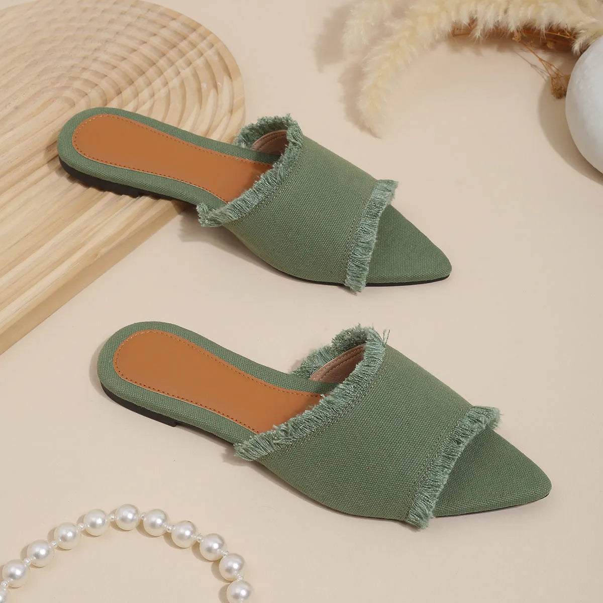 Women's denim flat slippers with tassel detail and leather lining in multiple colours.