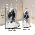 Silver Halloween ghost ornament with mosaic glass surface on wooden desk