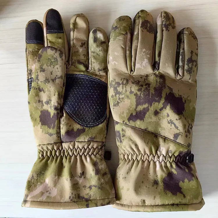 A pair of tactical camouflage ski gloves with touch-screen fingertips on a winter background.