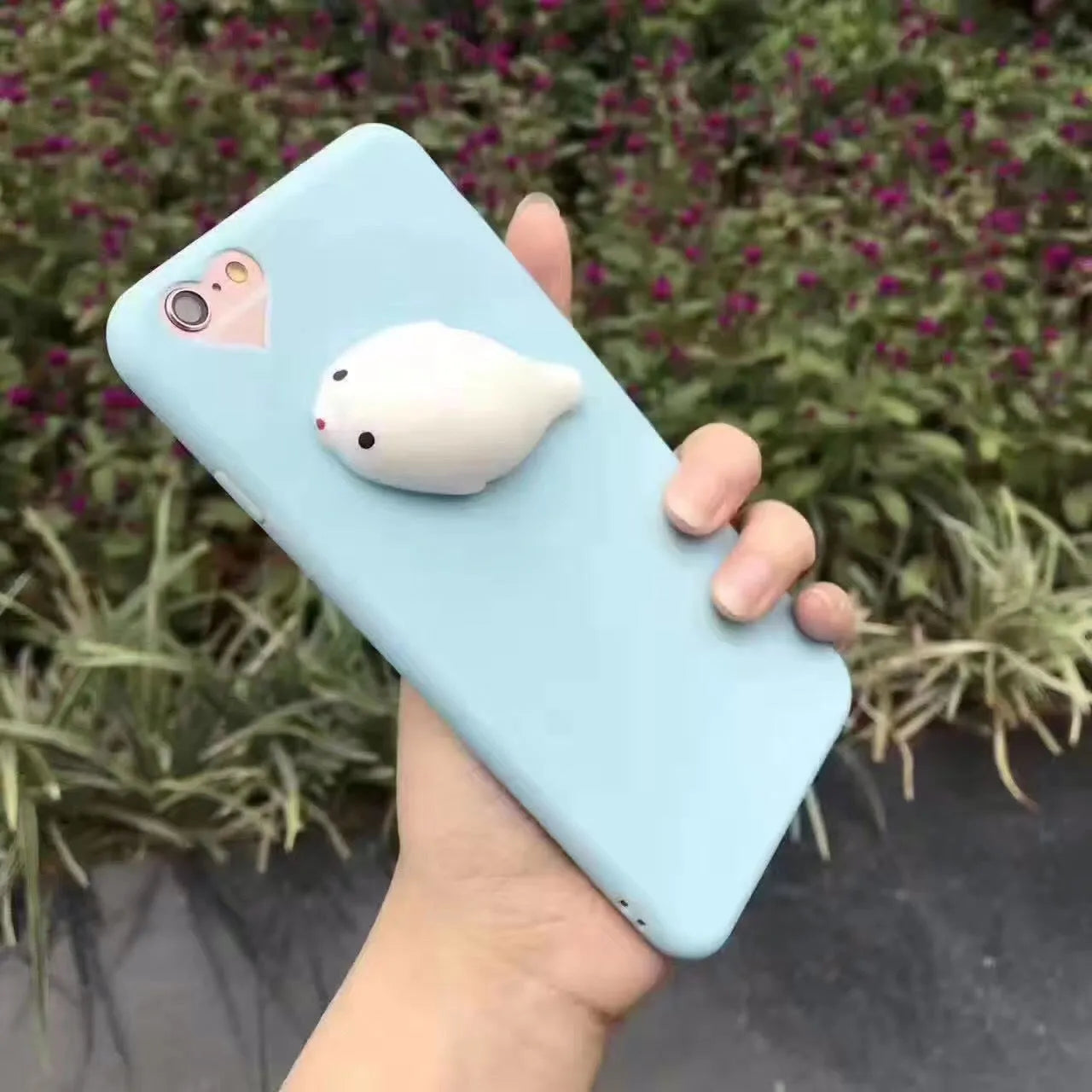 Soft pink TPU iPhone case with a raised white 3D cartoon cat design on the back.
