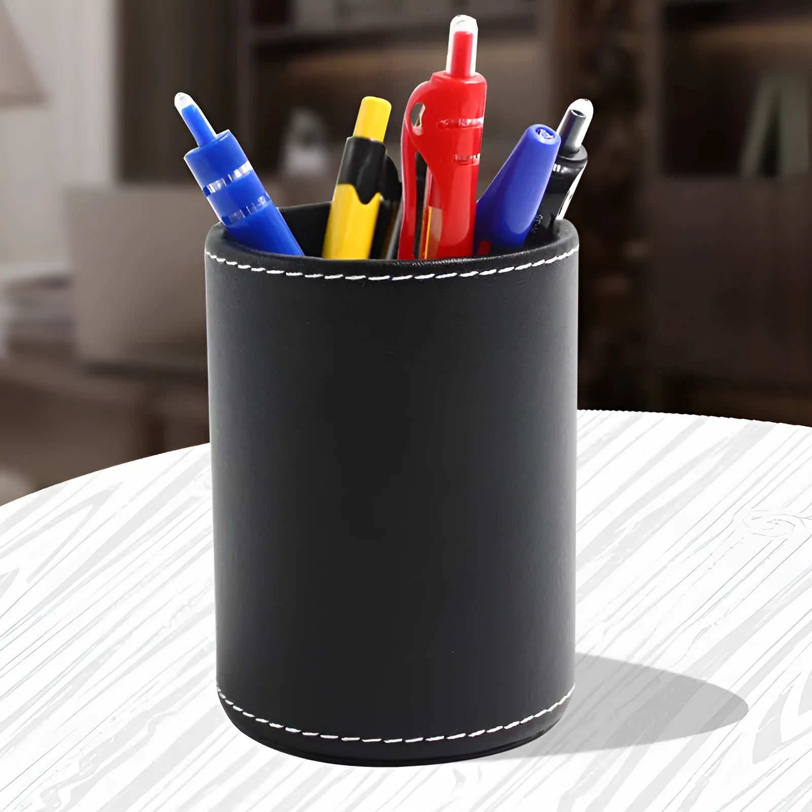 Round black leather pen holder showing cylindrical shape for desk organisation