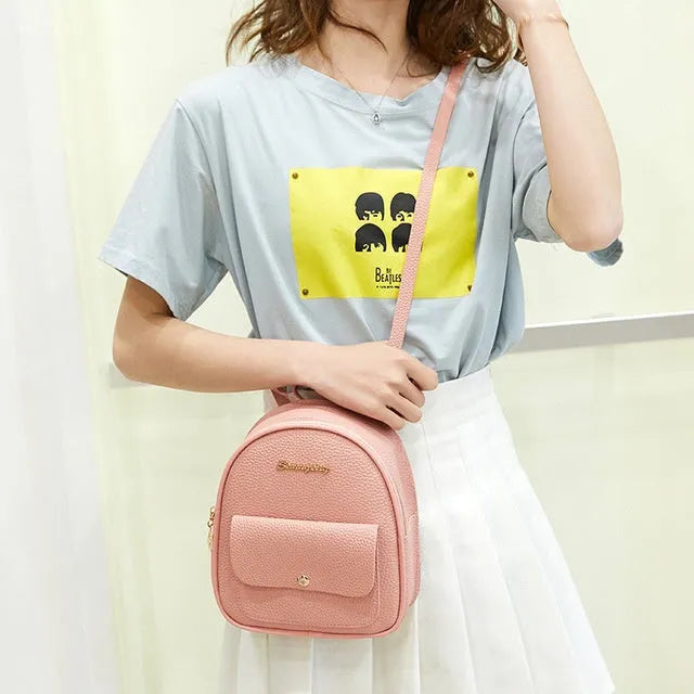 Compact black PU women's shoulder bag also worn as a small backpack, showing zipper closure.