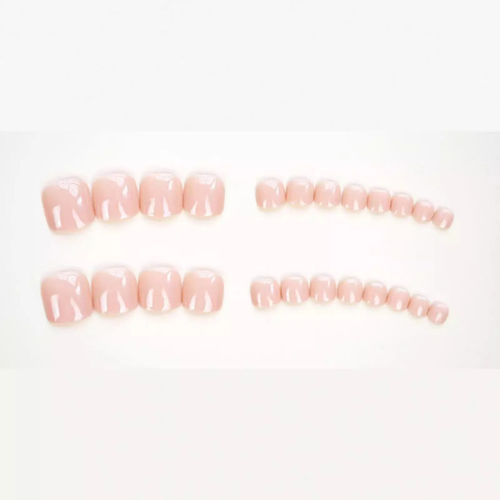 Pack of finished skin colour false toenails and a tube of adhesive glue for nail art.