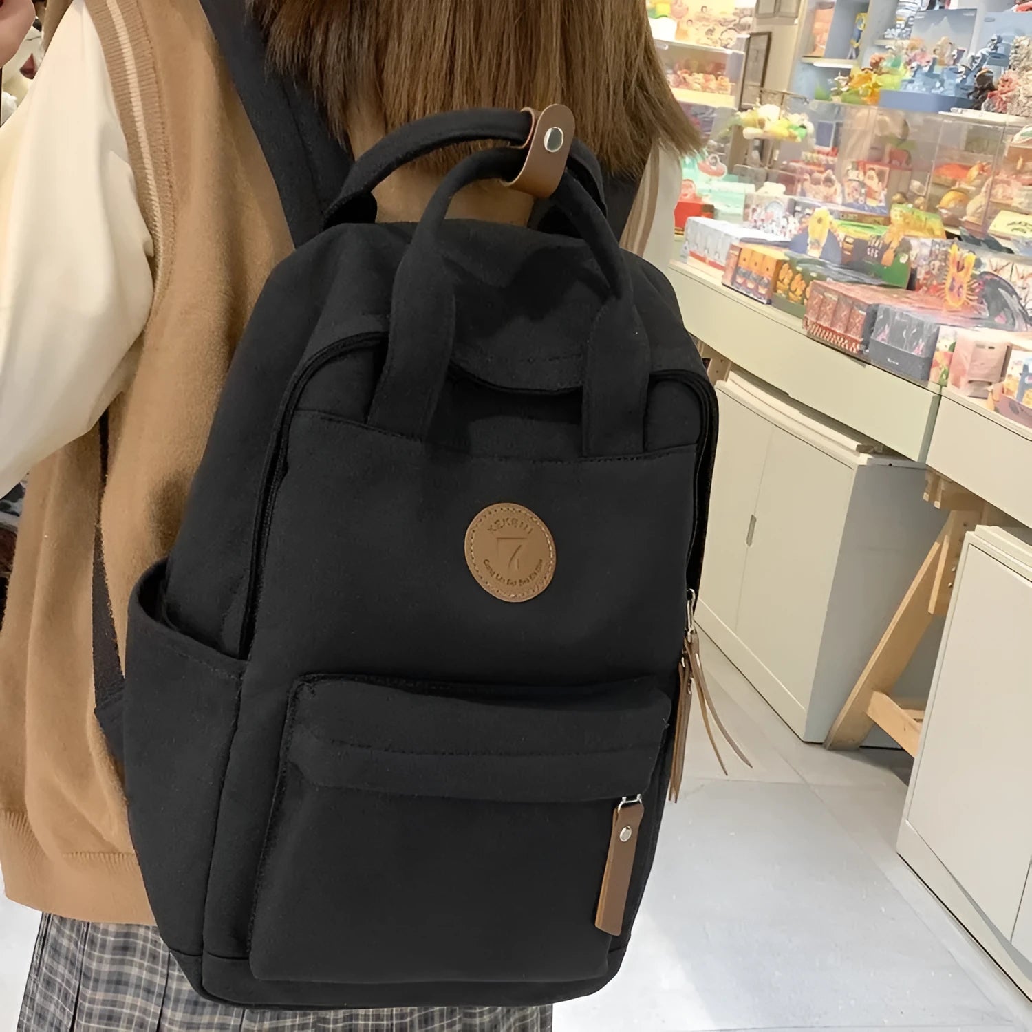 Solid black retro Oxford cloth backpack with curved shoulder straps on a neutral background.