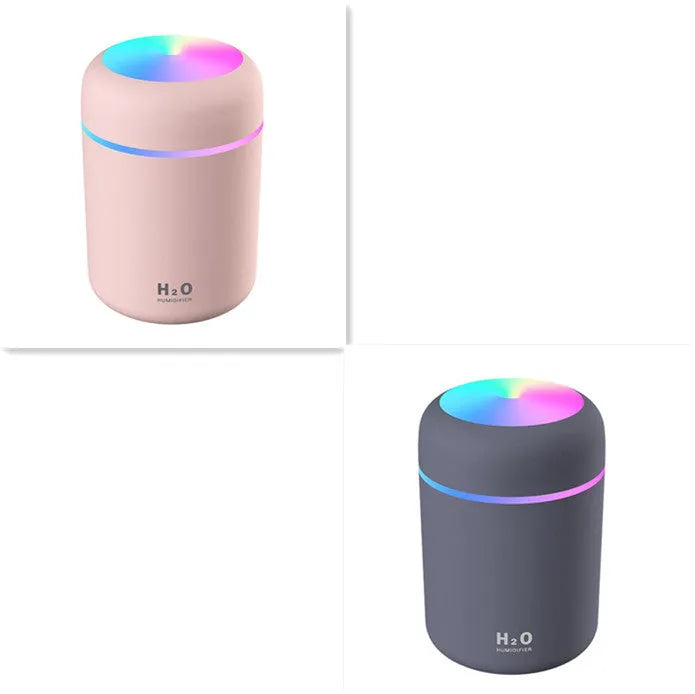 Pink USB mini humidifier with LED lights and water tank on desk