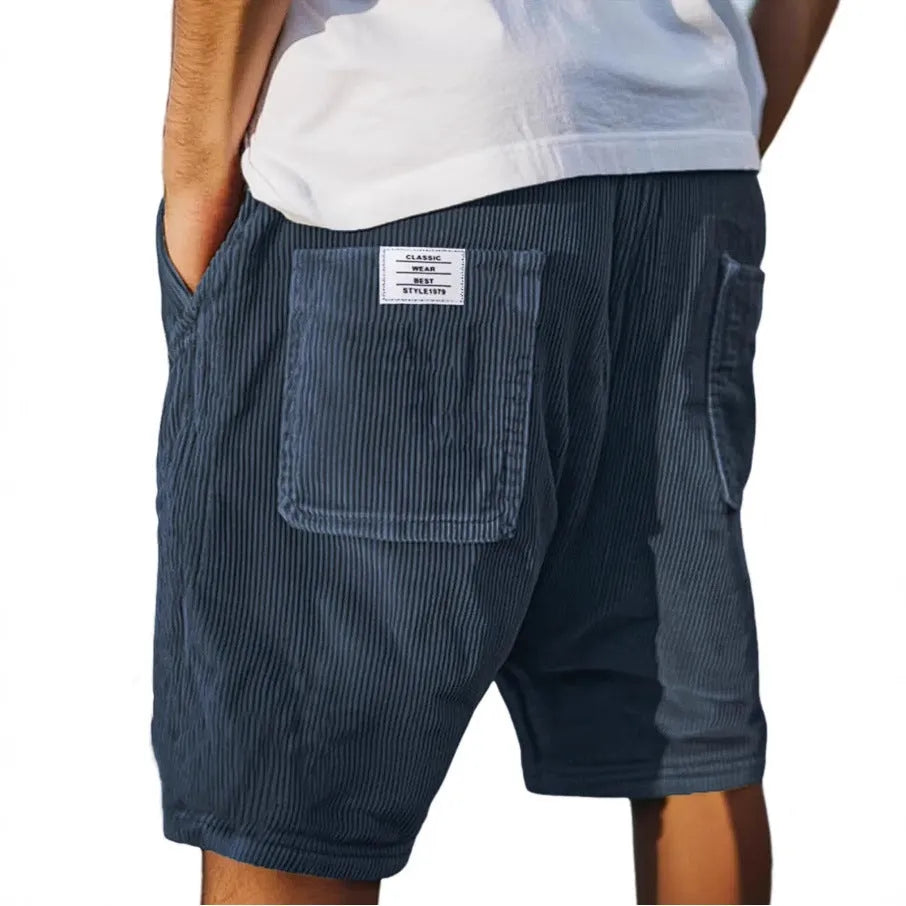 Men's grey corduroy shorts with embroidered detail on multiple pockets, laid flat.