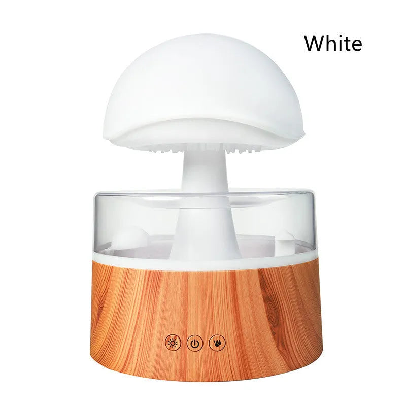 White cloud-shaped humidifier diffuser with LED rain effect and remote control on a wooden table.