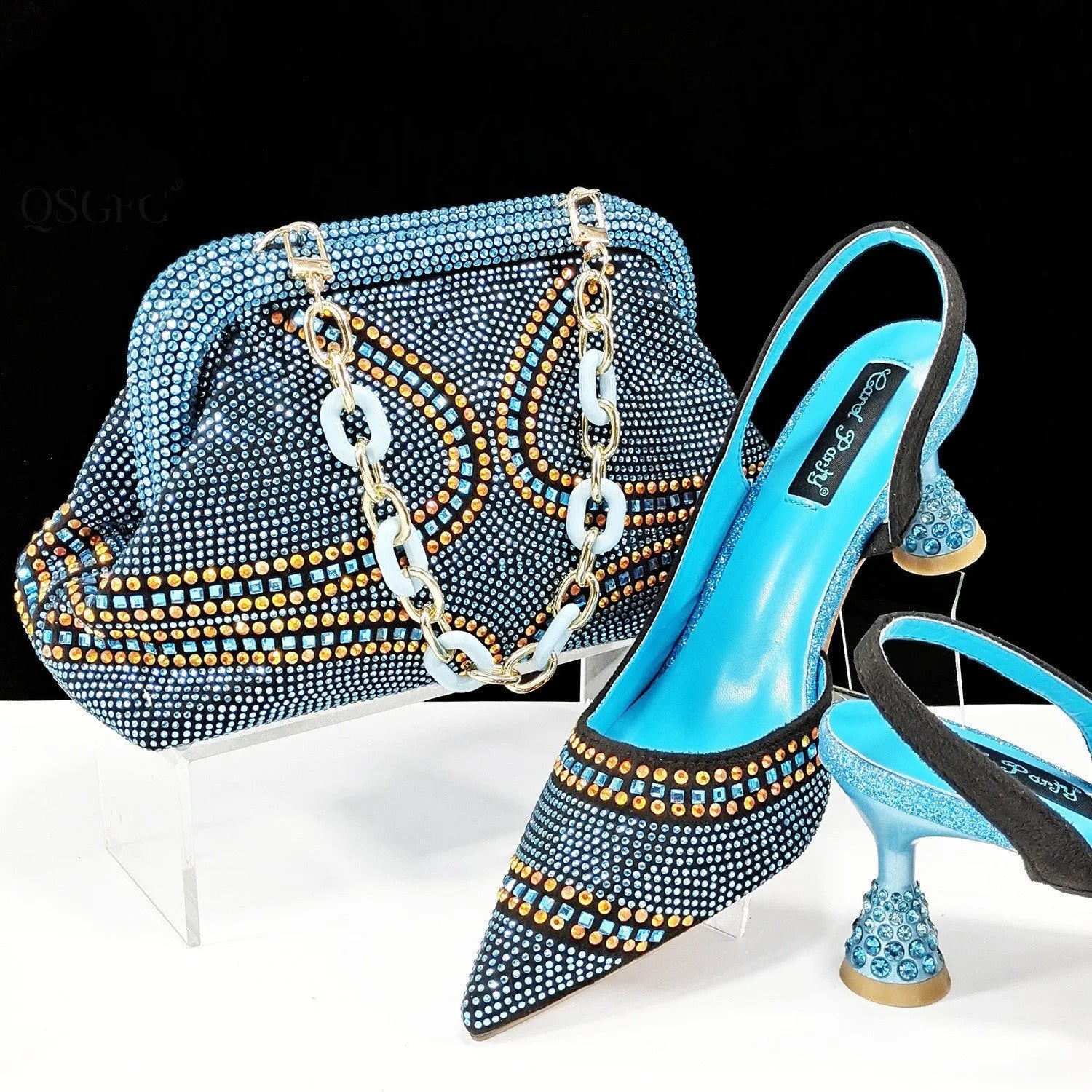 Women's pointed toe high heel shoes with decorative rhinestones and a matching small bag, shown in blue.