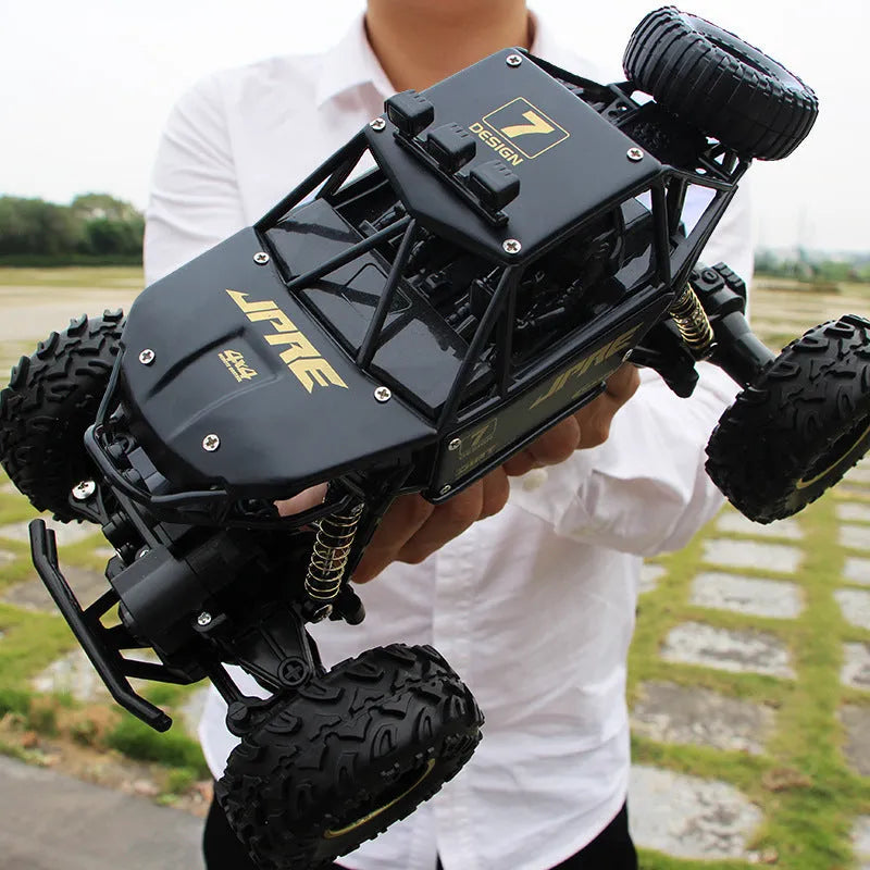 Black and silver remote control climbing cars with 2.4G wireless controller on a rough surface.