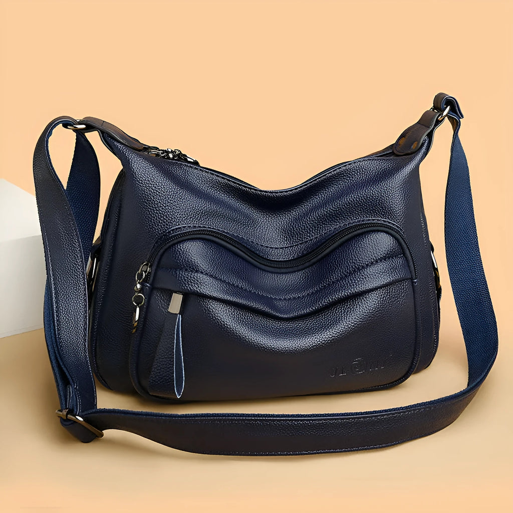 Women's blue soft PU crossbody bag showing interior phone and document compartments with zipper closure