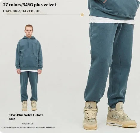 Men's dark brown velvet sweatpants with elastic waistband and banded ankle cuffs on hanger