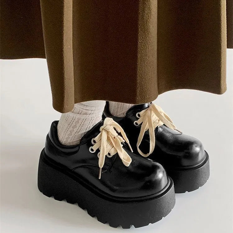 Matte black women's high-heel shoes with a thick rubber sole and lace-up buckle.
