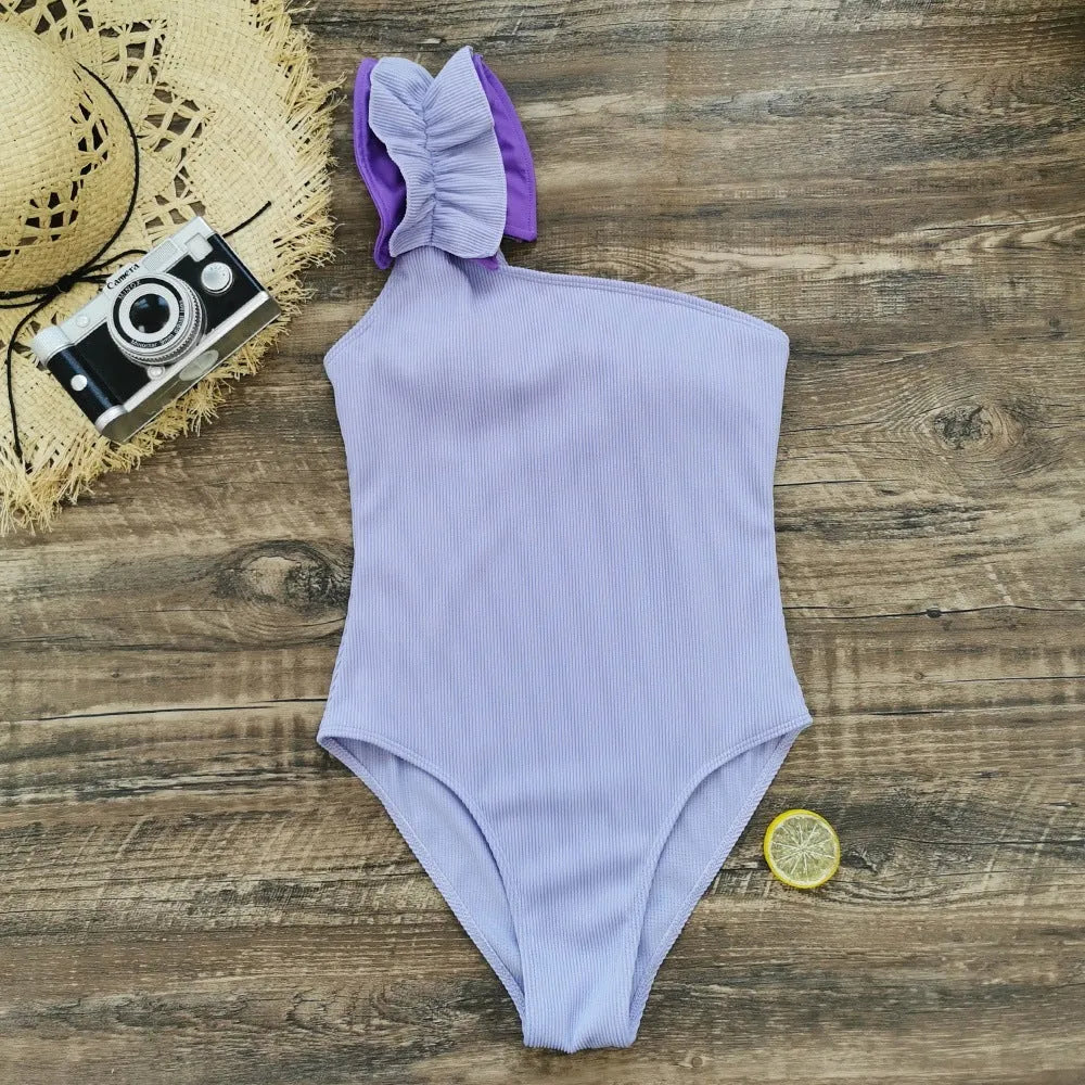 Women's solid colour single-shoulder two-piece swimsuit with high-waist bottoms on a mannequin.