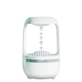 White anti-gravity humidifier with water droplet effect on a desk next to a USB cable.