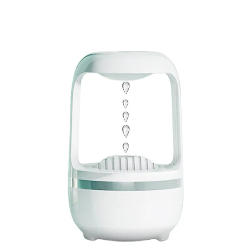 White anti-gravity humidifier with water droplet effect on a desk next to a USB cable.
