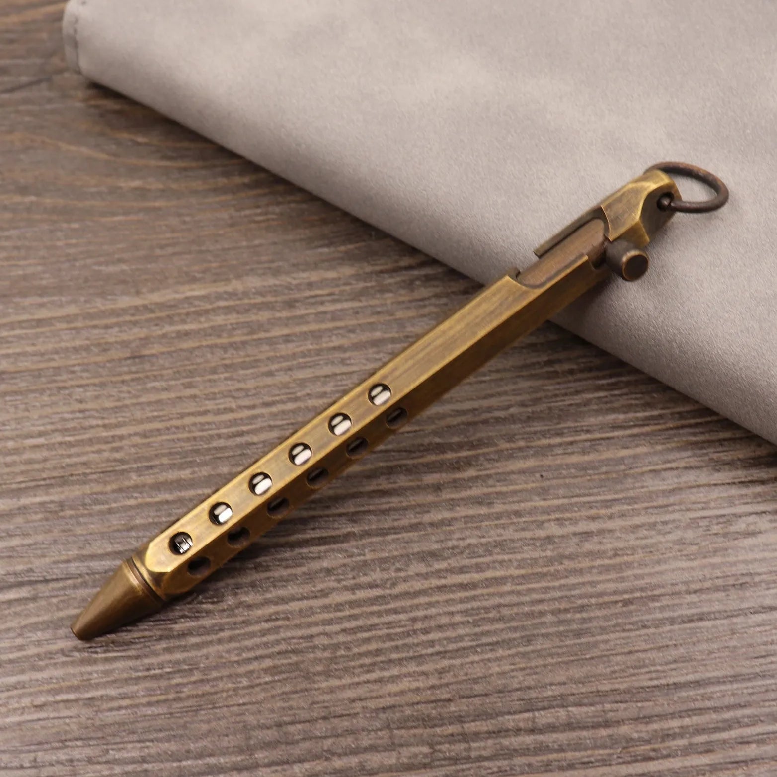 Retro brass tactical pen with press bolt-action mechanism and cylindrical metal barrel