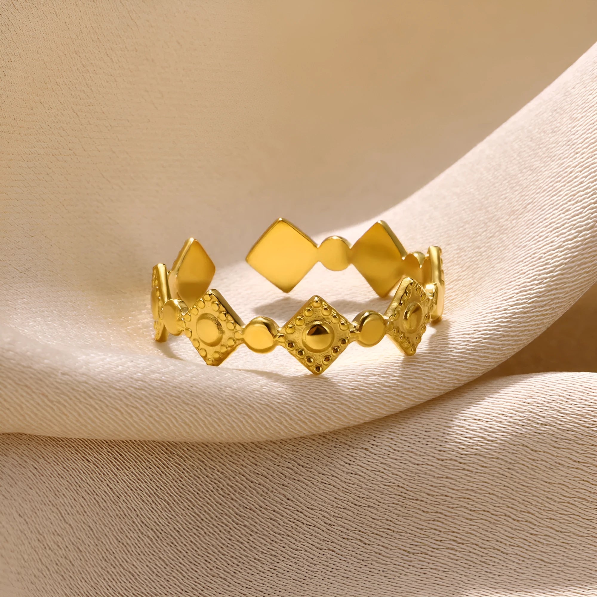 Gold diamond coloured titanium steel geometric women's ring on a plain background.