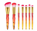 Ten crystal-handle foundation makeup brushes with synthetic bristles laid out flat