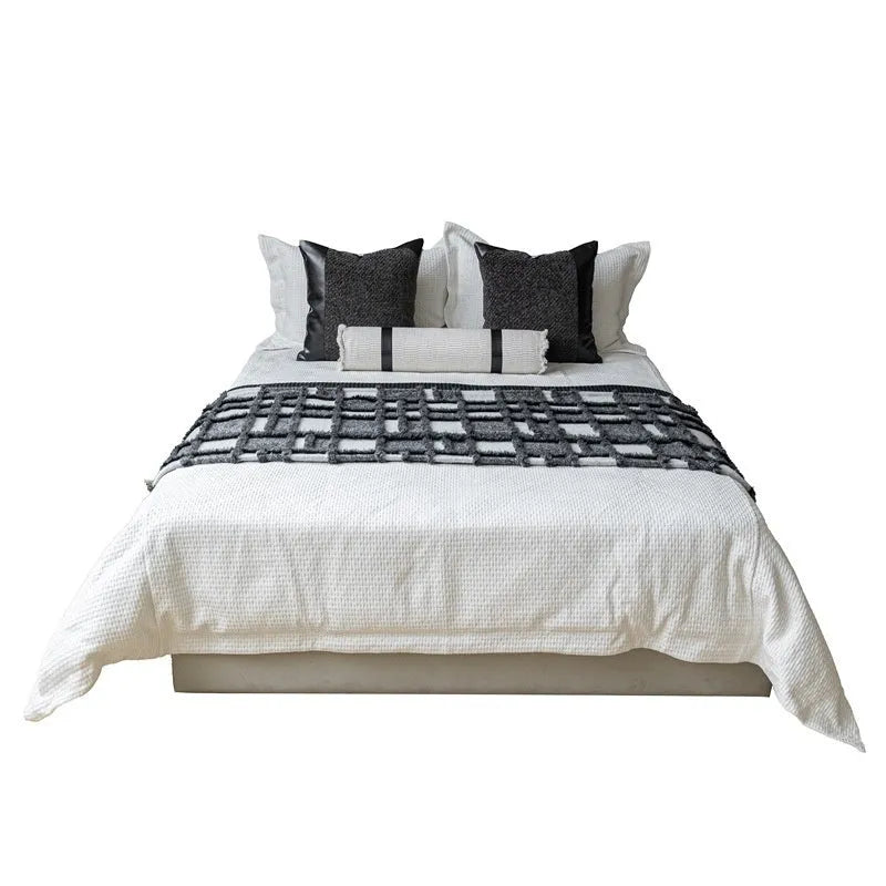 Modern minimalist grey and white plaid bed runner blanket set with matching pillow on a double bed