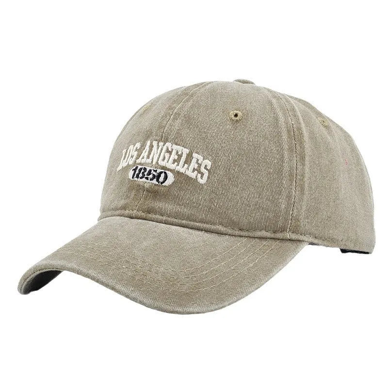 Retro washed distressed embroidered peaked cap with adjustable strap on a conical crown.