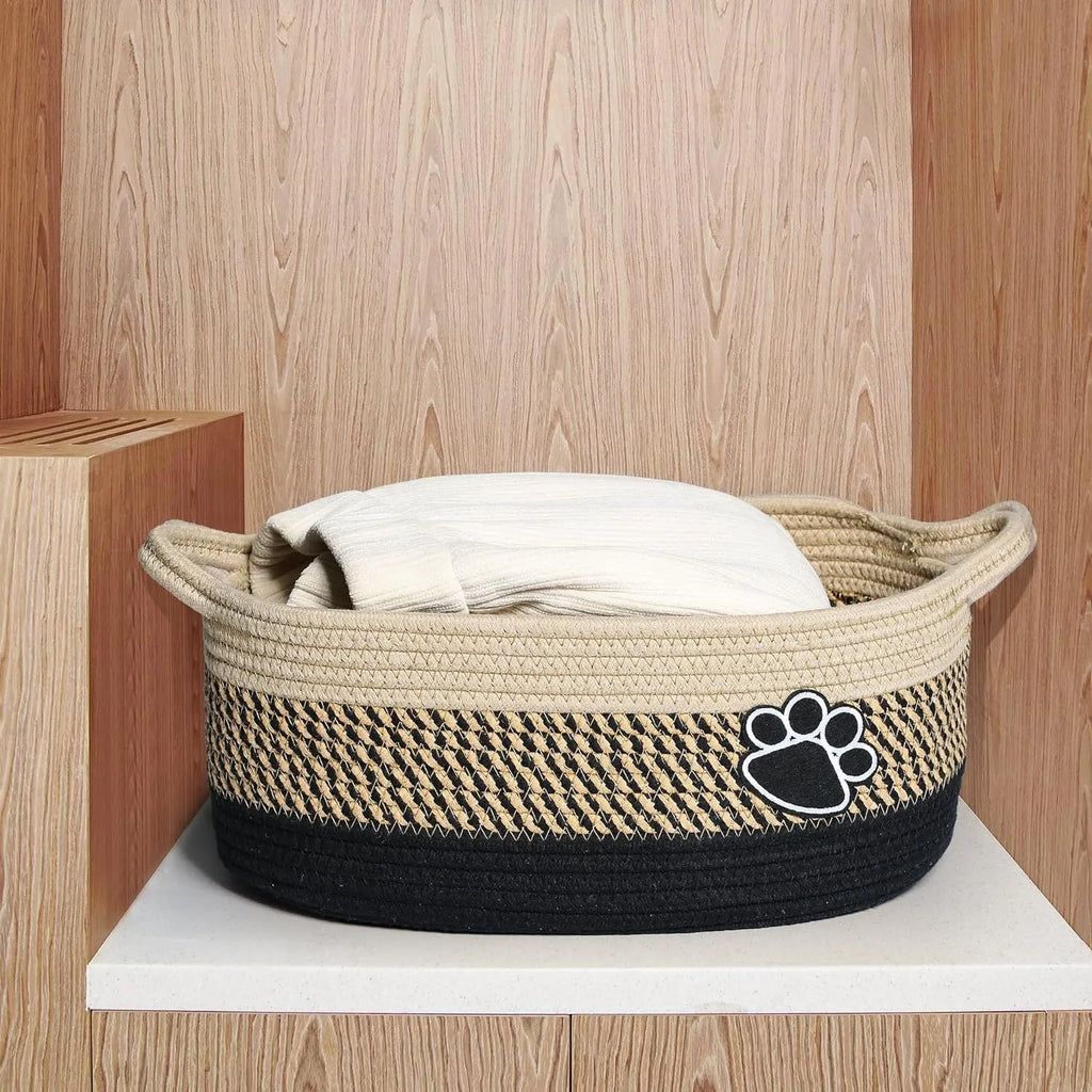 Small light beige handwoven cotton rope storage basket with a wooden handle.