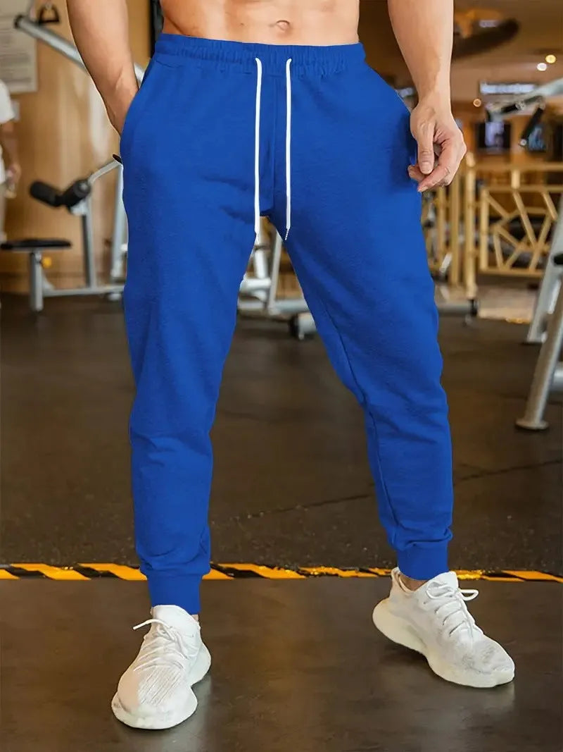 Men's loose fit linen-style trousers with a drawstring elastic waist, shown in a casual setting.