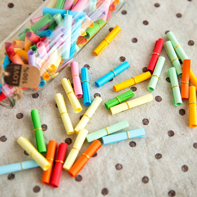 Assorted colourful scroll-style paper notes with metal eyelets in four different sizes.