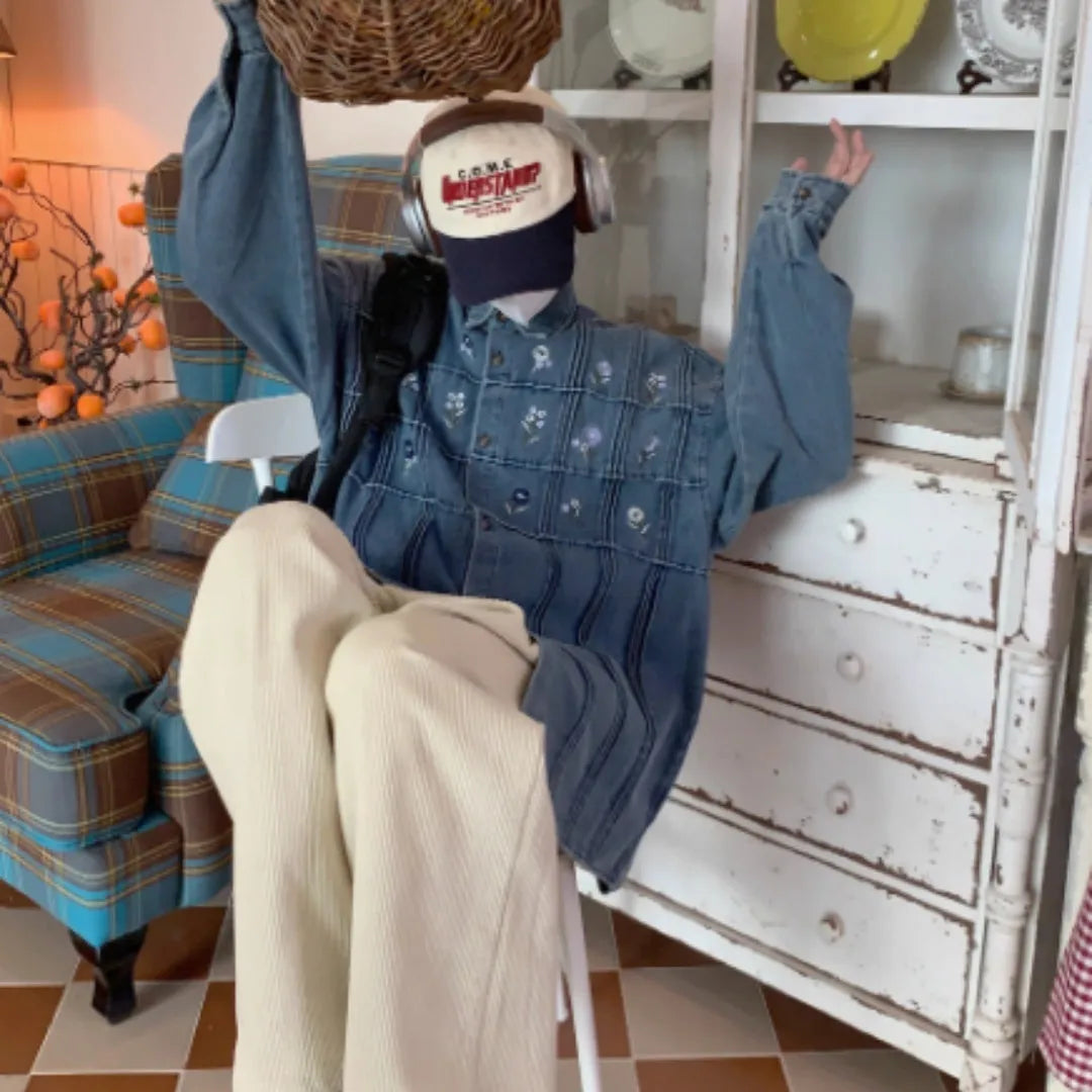 Washed blue denim long sleeve shirt with small floral pleated details on front.