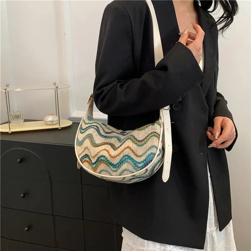 Women's straw woven crossbody bag showing knitted weaving texture and internal phone pocket