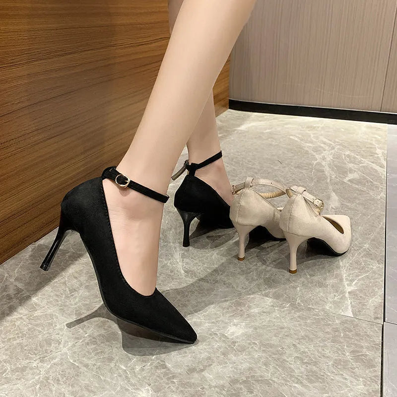 Women's black stiletto heel pump shoe with a silver buckle detail on the front.