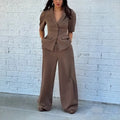 Brown polyester men's two-piece suit with slim-fit trousers and long-sleeve top on hanger