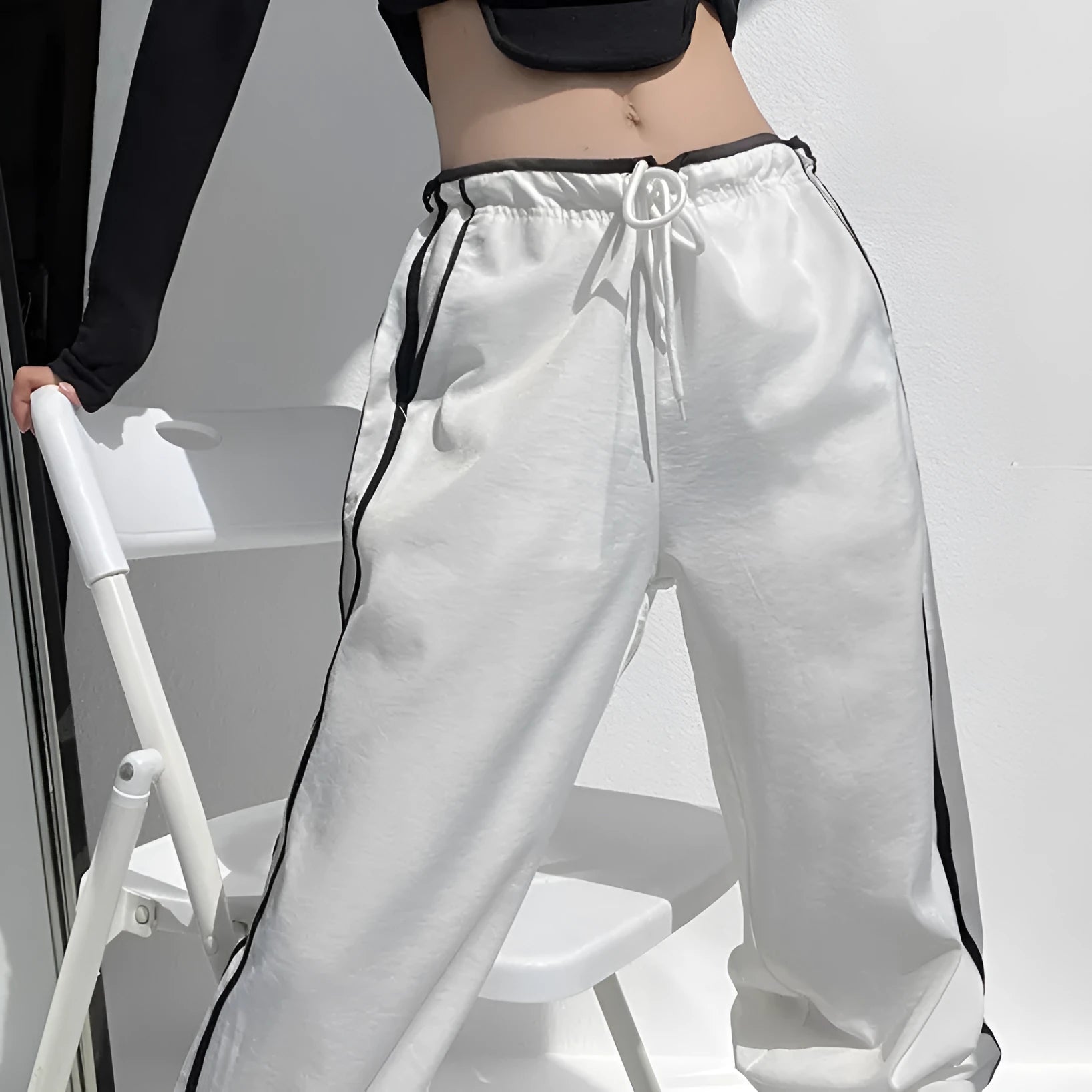 Women's navy blue loose straight leg trousers with ribbon parallel bars detail on the leg.