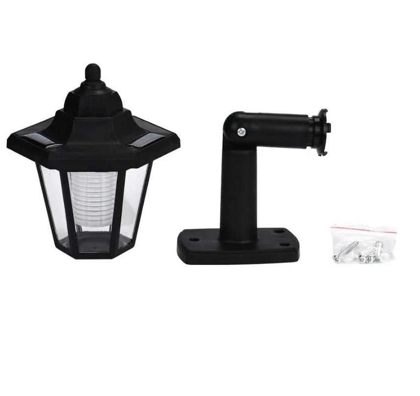 Black hexagonal solar wall lamp with light sensor mounted on an outdoor wall