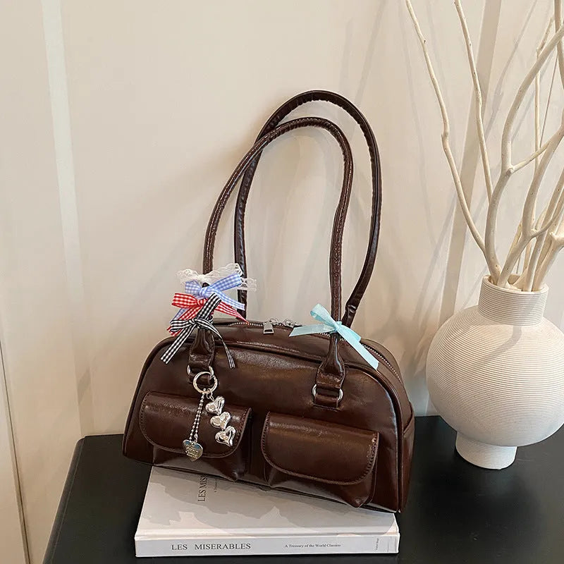 Retro brown PU leather women's pillow handbag with a flap and double shoulder strap on a neutral background.