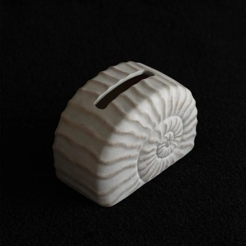 Resin conch seashell tissue box decoration in conch ramble colour on a table.