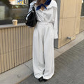 White striped wide-leg trousers with front zipper detail and loose casual fit