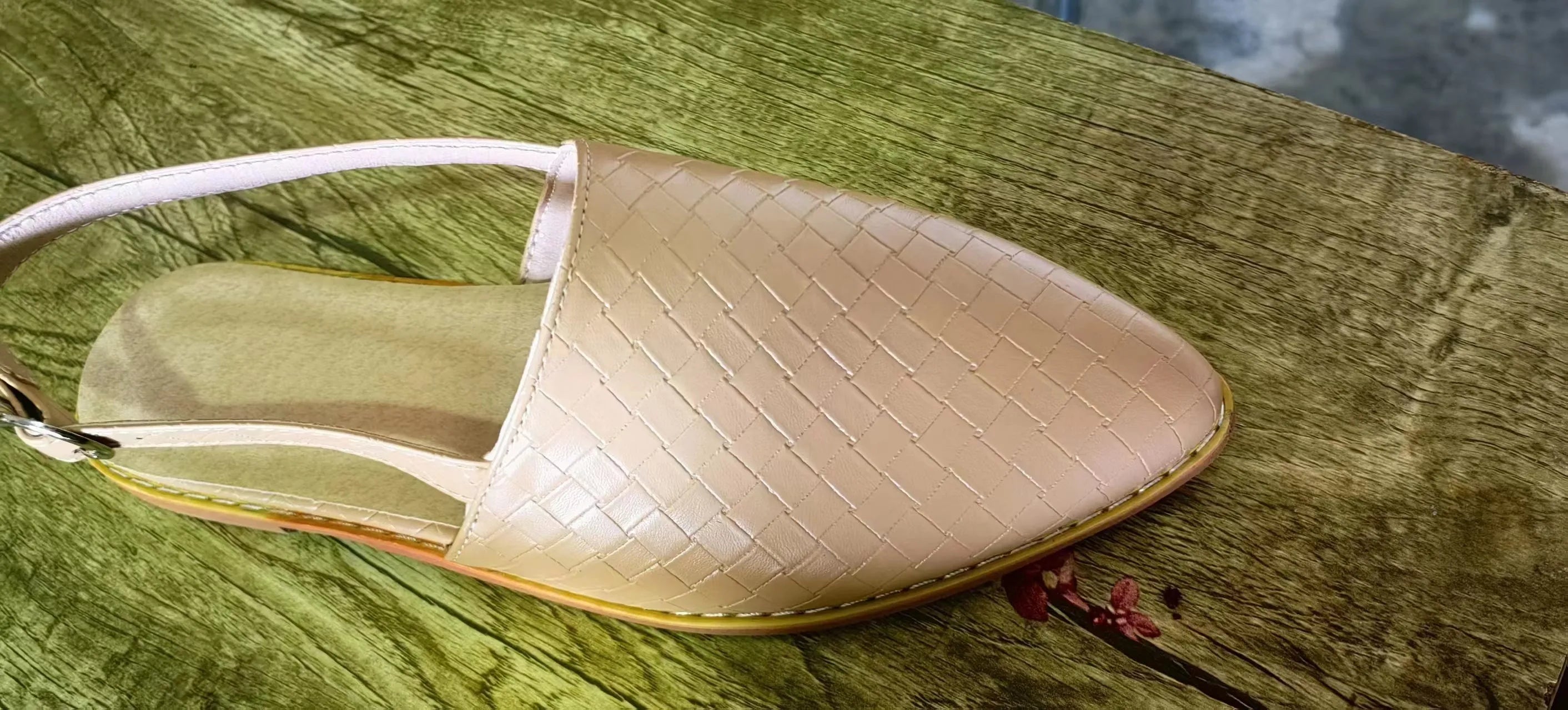 A pair of flat buckle sandals with a pointed toe, shown in one of the available colours.