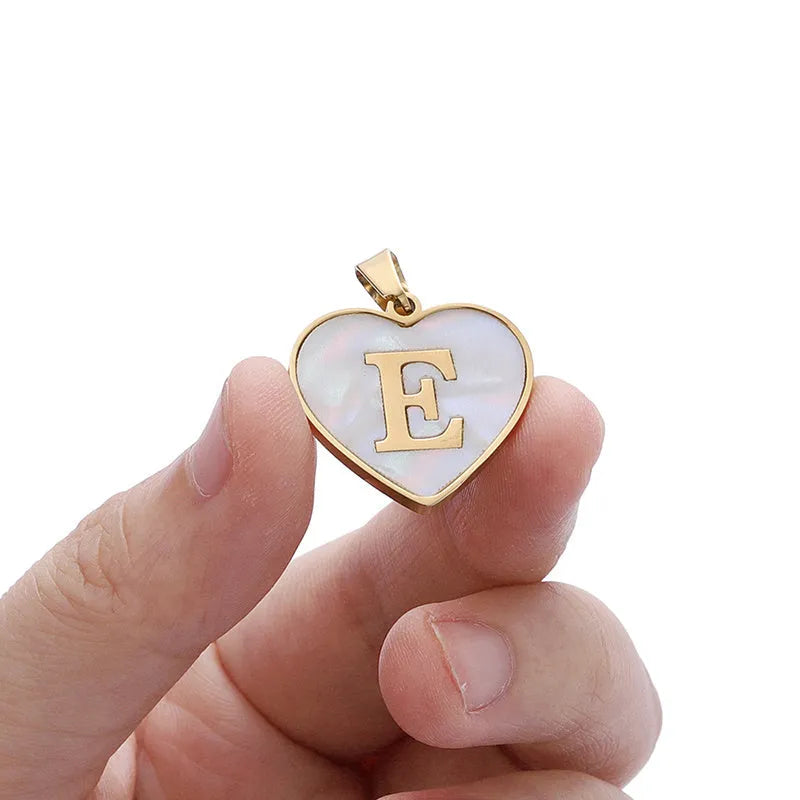 Gold-plated heart necklace with white shell pendant personalised with a letter, on an adjustable chain.