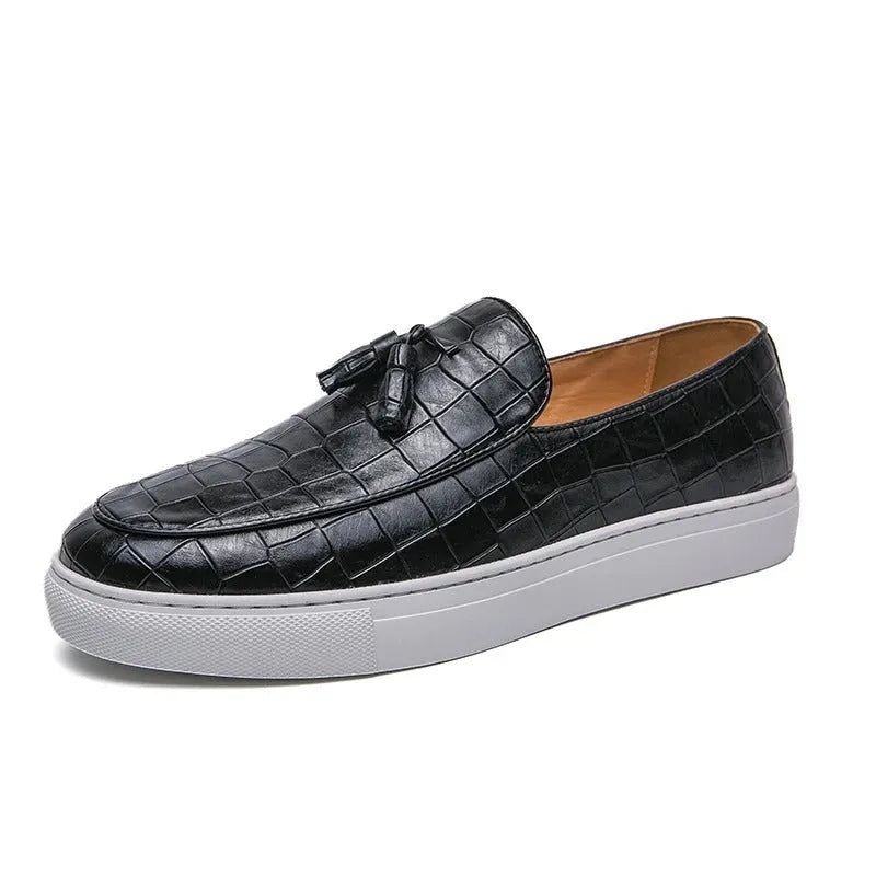 Men's black tassel detail slip-on sneakers on a white background, showing the round toe and elastic side.